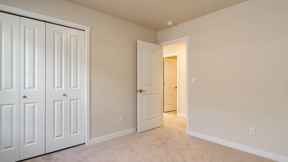 Bedroom with wall-to-wall carpet and a closet