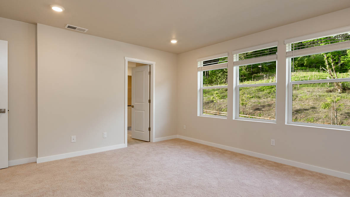 Primary bedroom with wall-to-wall carpet, a walk-in closet and an attached bathroom