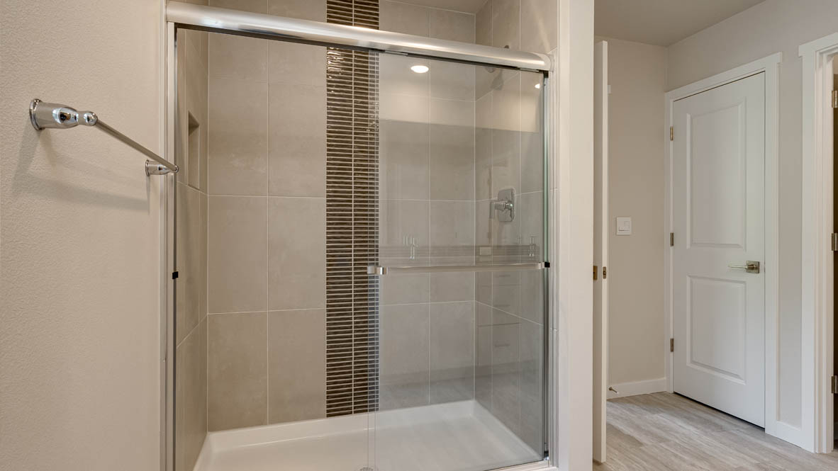 Primary bathroom with quartz counters and a walk-in shower