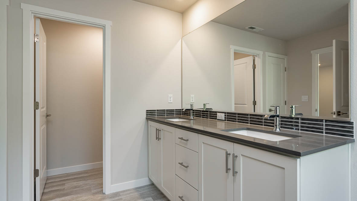 Primary bathroom with quartz counters and a walk-in shower
