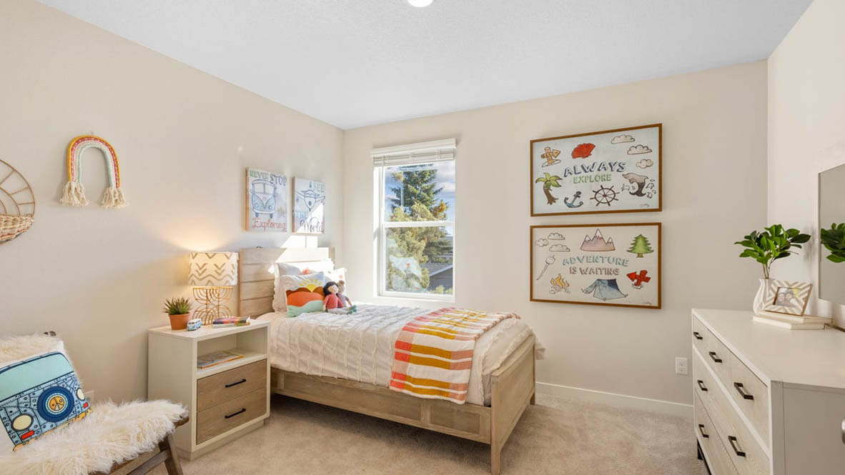 Avery Terrace Bedroom with a bed with sheets, light stained bed frame, end table with a lamp, paintings, and a window