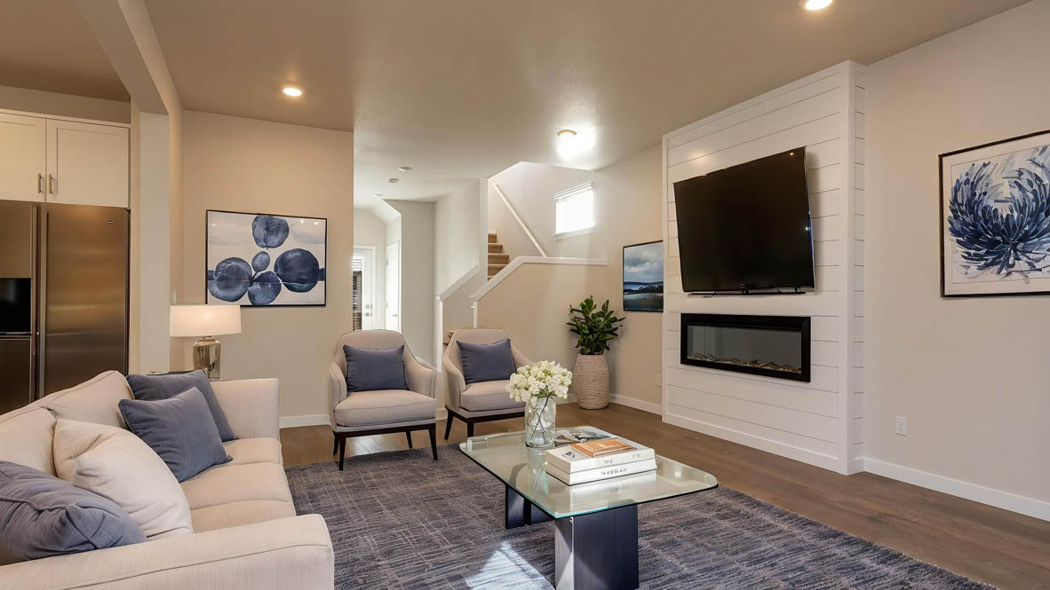 Avery Terrace Great room with large couch over a rug and surrounding a coffee table facing the fire place