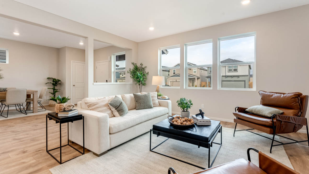 Avery Terrace Great room with large sectional couch over a rug and surrounding a coffee table facing the fire place