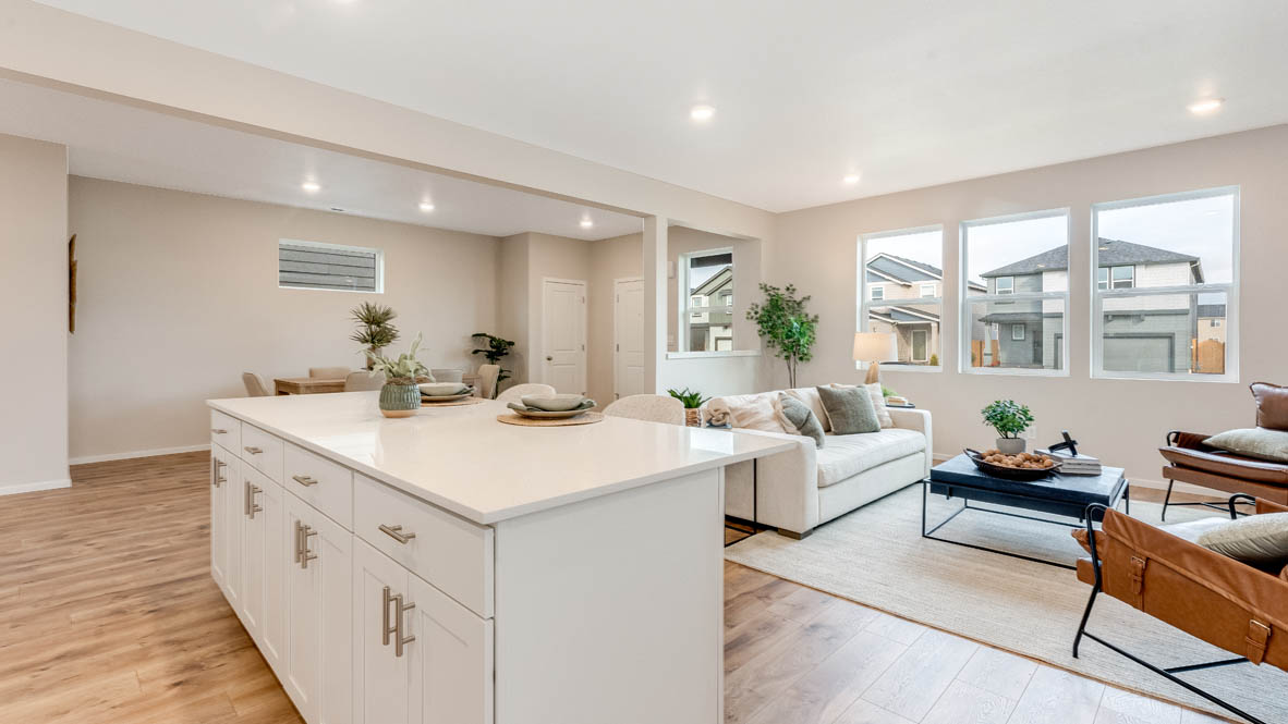 Avery Terrace Kitchen with stainless steel appliances, island, soft closed cabinets, and the great room in the background