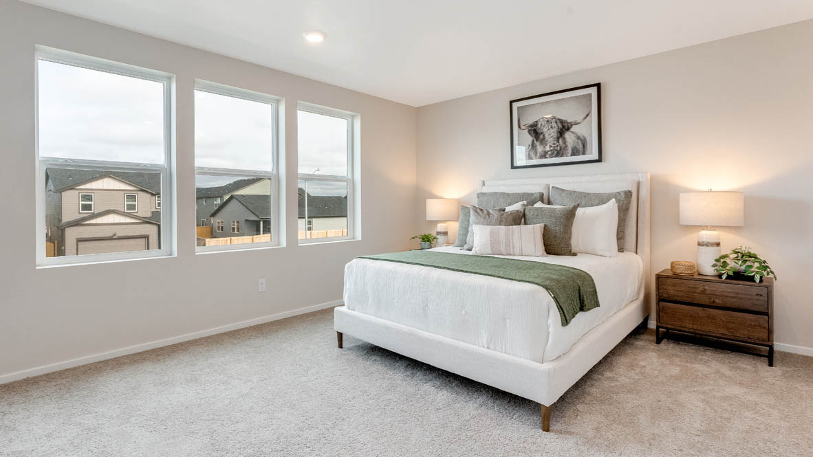 Avery Terrace Primary bedroom with a painting, large bed with two side tables one on either side of the bed. Carpeted flooring and windows