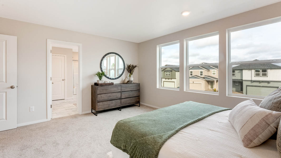 Avery Terrace Primary bedroom with a painting, large bed with two side tables one on either side of the bed. Carpeted flooring and windows, and a dresser