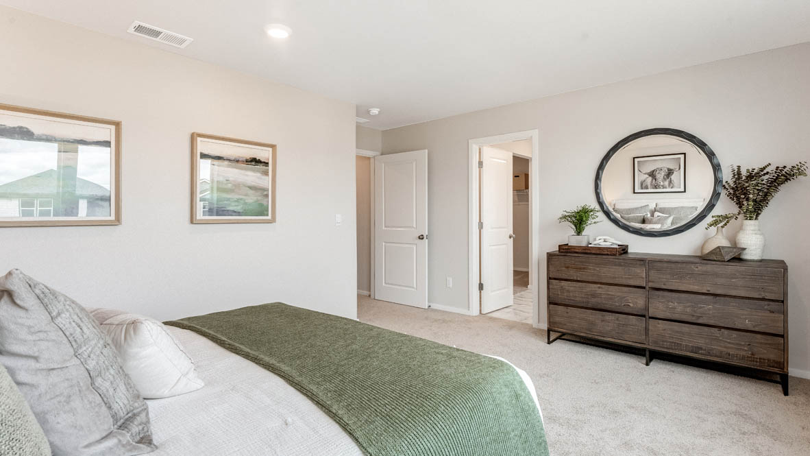Avery Terrace Primary bedroom with a painting, large bed with two side tables one on either side of the bed. Carpeted flooring and windows, and a dresser