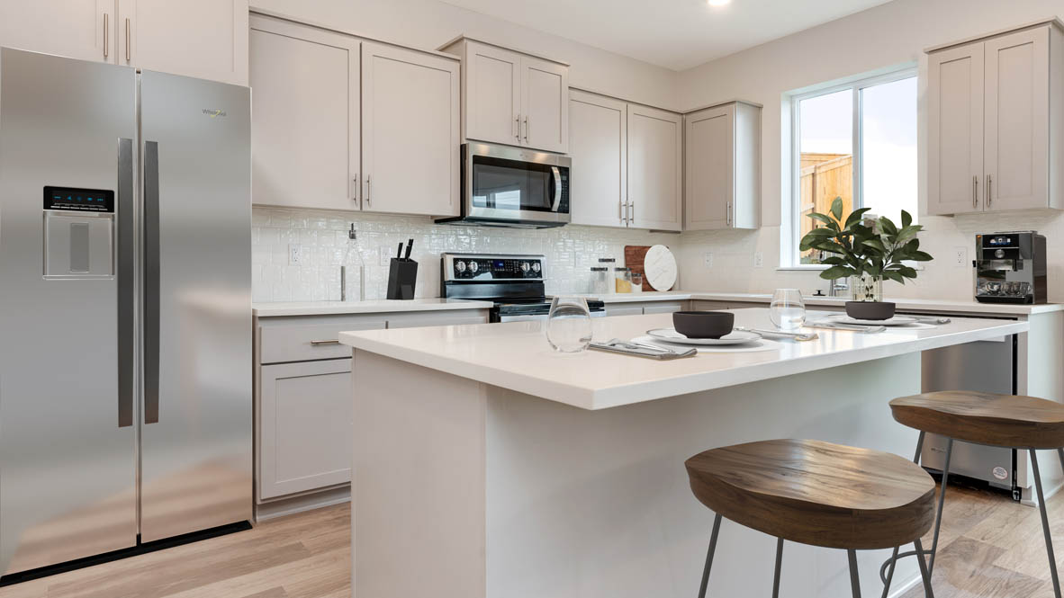 Avery Terrace kitchen with bar stools and stainless steel appliances and white shaker style cabinets