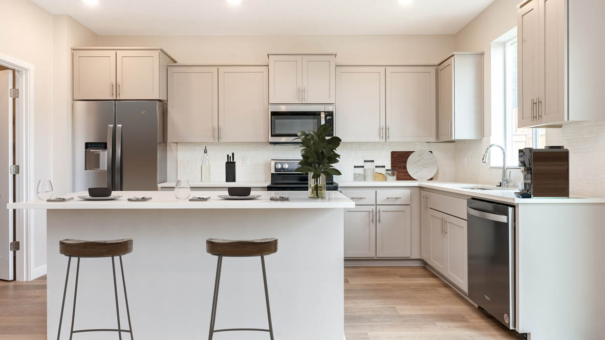 Avery Terrace kitchen with bar stools and stainless steel appliances and white shaker style cabinets