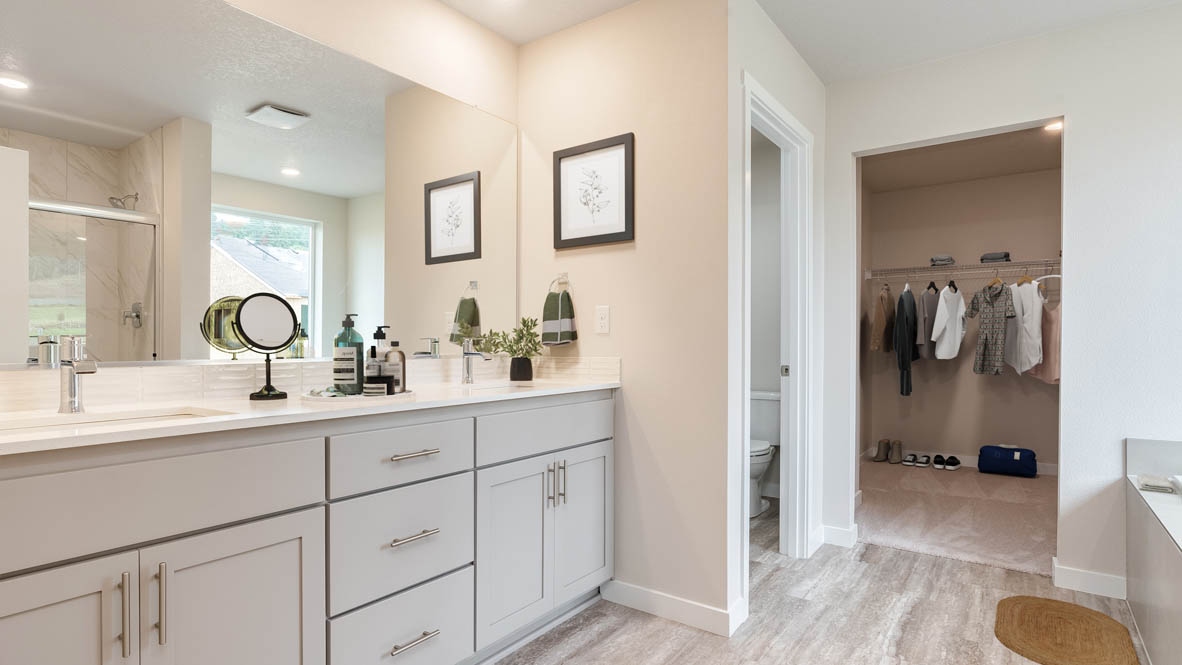 Avery Terrace primary bathroom with two sink vanity and shaker style cabinets and a walk in closet