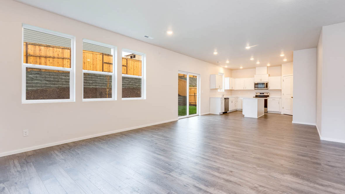 Avery Terrace great room with windows, white walls, and kitchen in the background