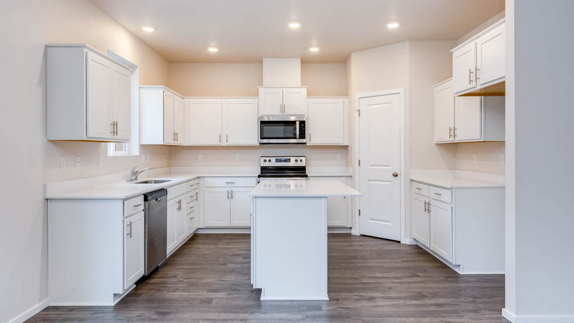 Avery terrace Kitchen with quartz countertops, island, stainless steel appliances, cabinets, and a window