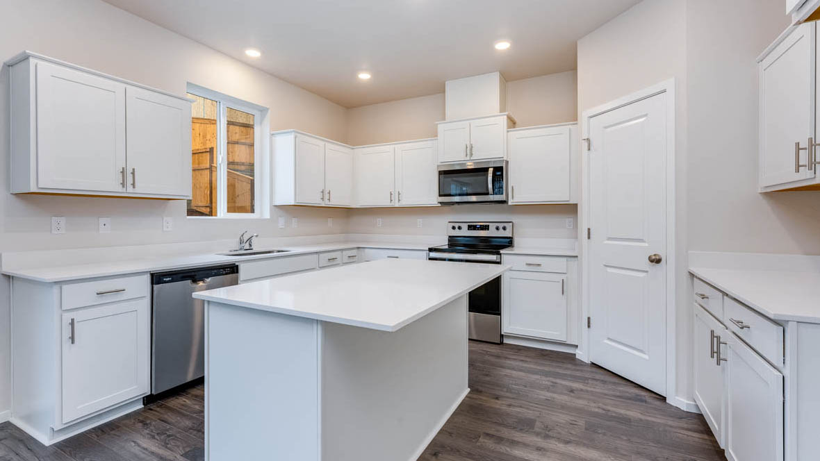 Avery terrace Kitchen with quartz countertops, island, stainless steel appliances, cabinets, and a window