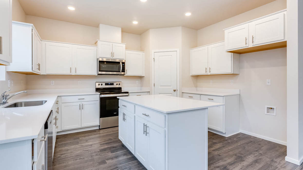 Avery terrace Kitchen with quartz countertops, island, stainless steel appliances, cabinets, and a window