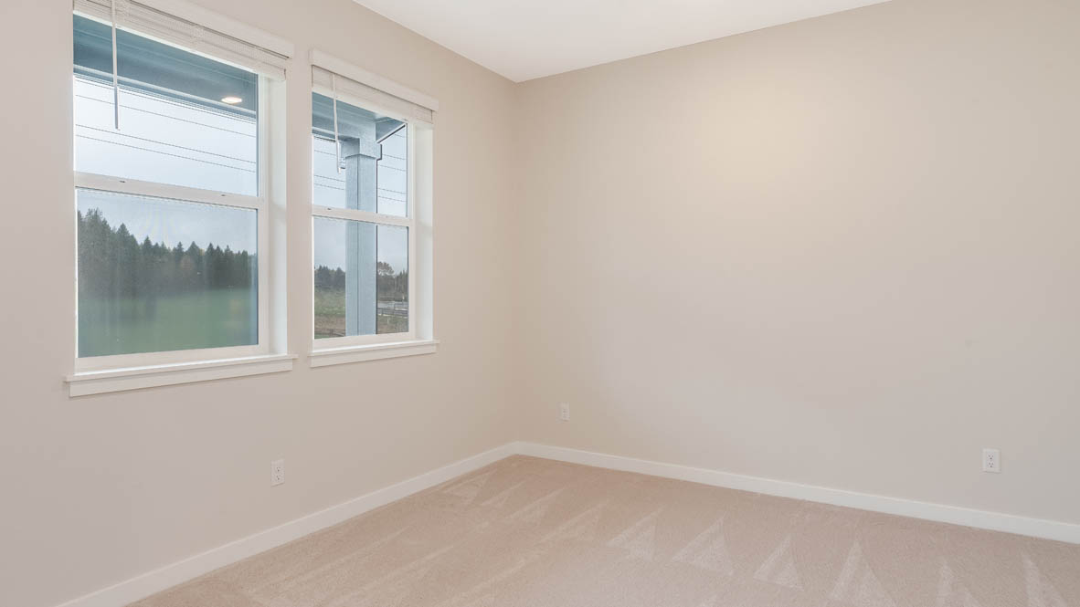 Avery Terrace Den with carpet, white walls, and a window