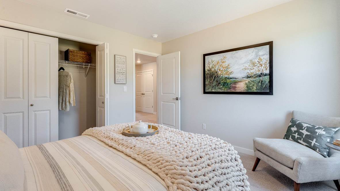 Avery Terrace Bedroom with gray accent wall and full/queen size bed and a corner chair