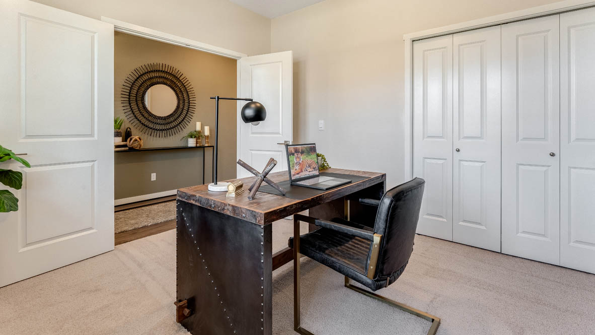 Avery Terrace Den set up as an office with a desk and decorative shelving