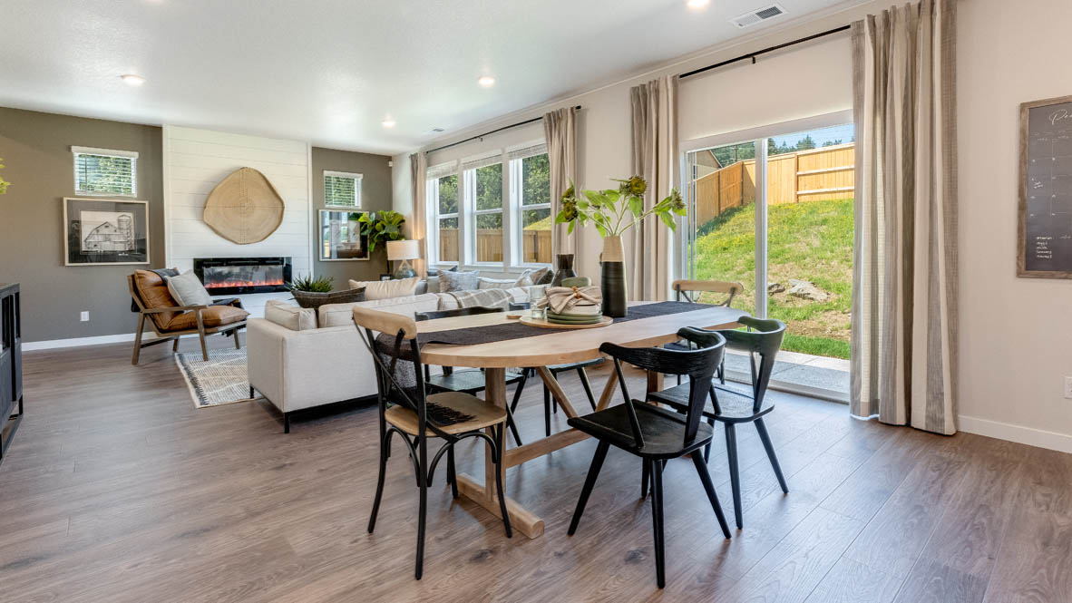 Avery Terrace Dining room with a table set for six chairs and the kitchen with stainless steel appliances