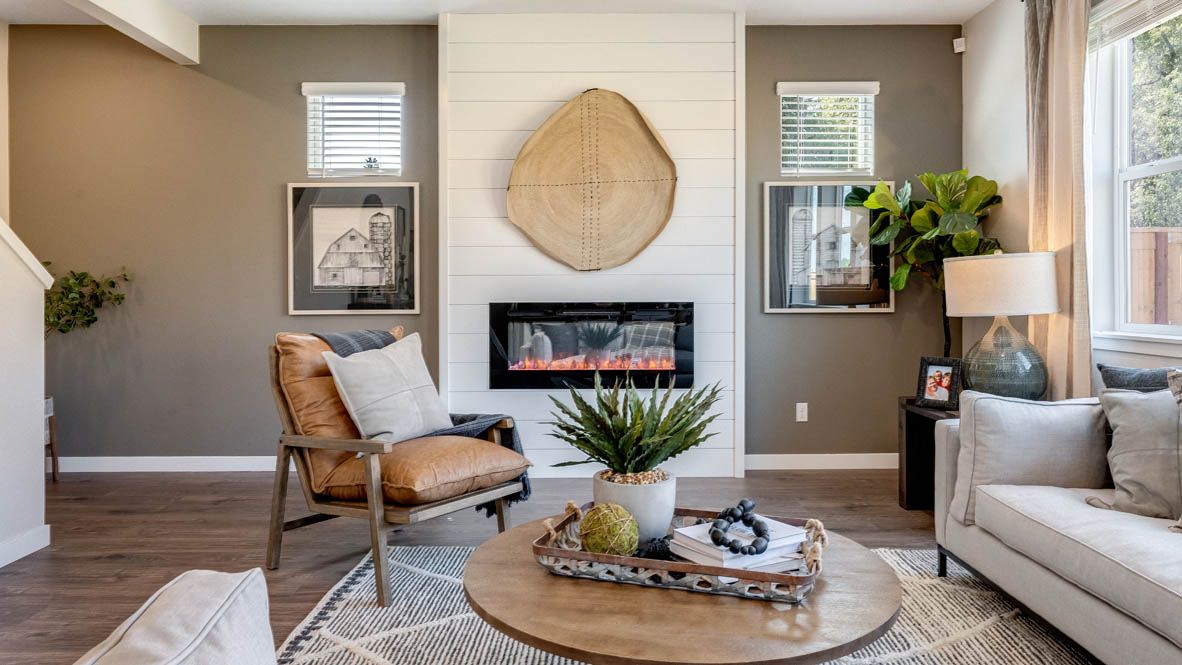 Avery Terrace Great room with large sectional couch over a rug and surrounding a coffee table facing the fire place