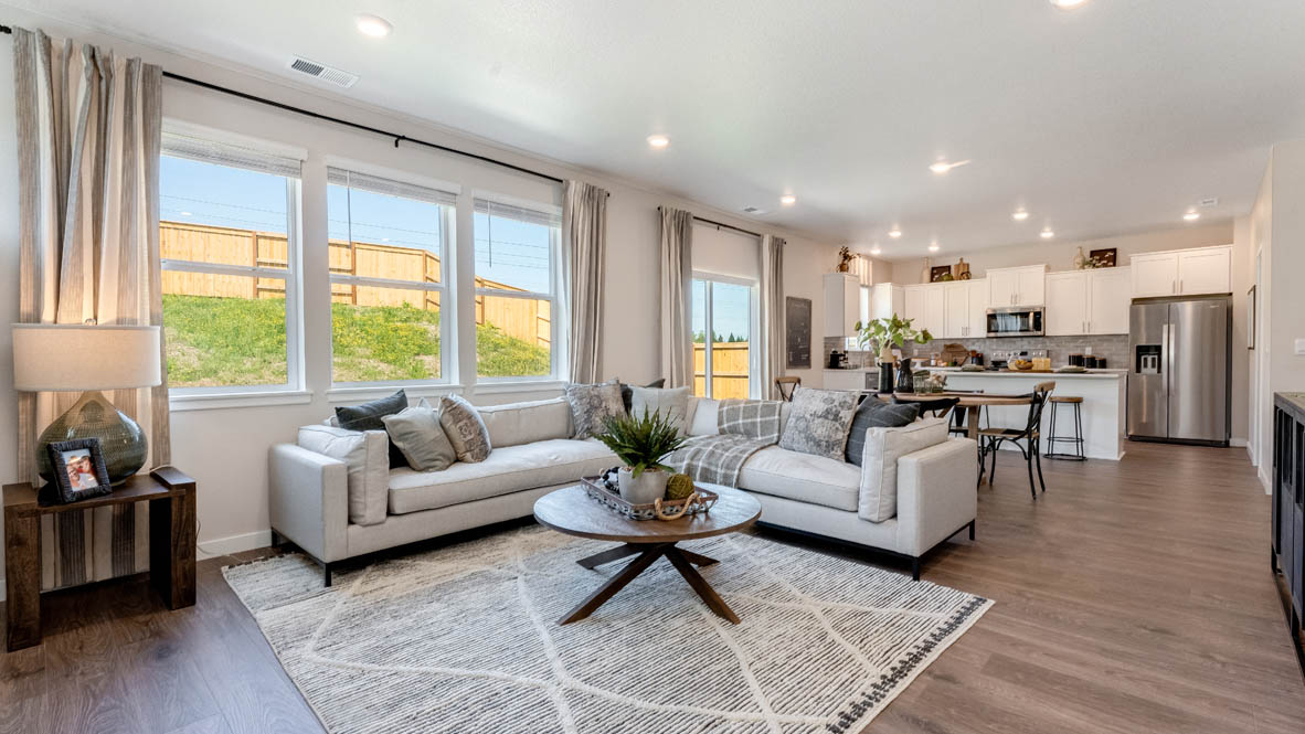 Avery Terrace Great room with large sectional couch over a rug and surrounding a coffee table facing the fire place
