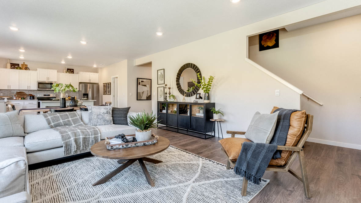 Avery Terrace Great room with large sectional couch over a rug and surrounding a coffee table facing the fire place