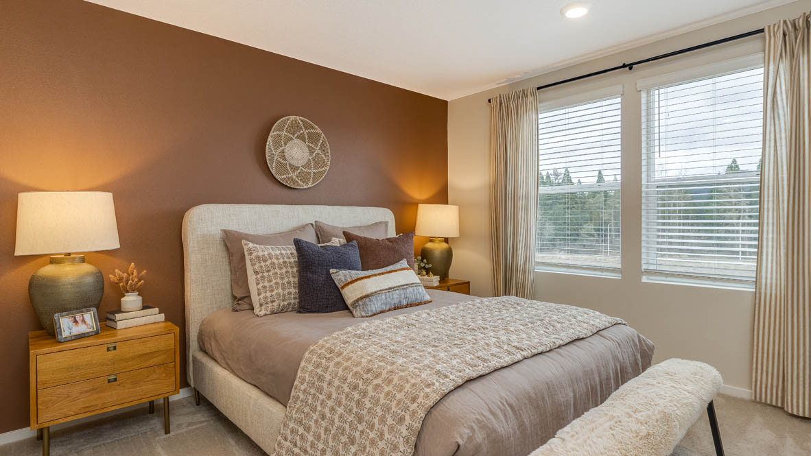 Avery Terrace primary bedroom with queen size bed, comforter set with pillow, lamps and nightstands, windows, and carpet