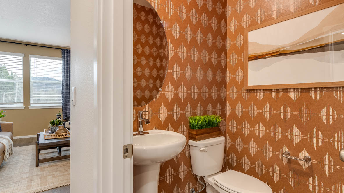 Avery Terrace Powder room with pattern wall, single sink vanity, painting, toilet, mini plant