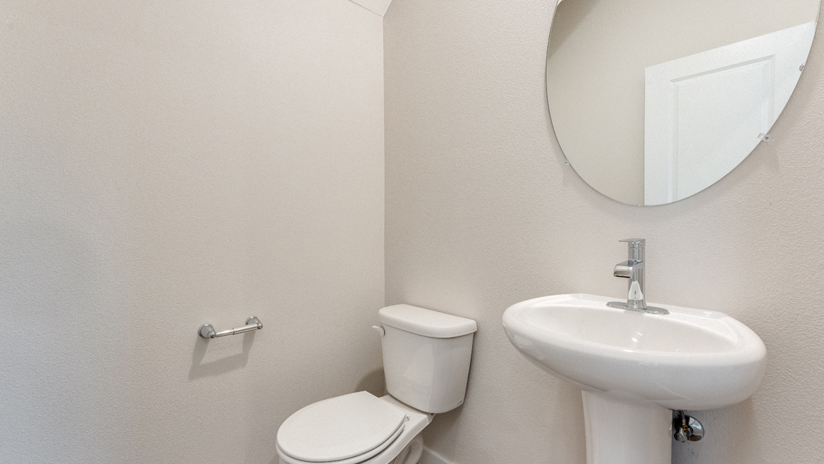 Avery Terrace Powder room with single sink vanity, circular mirror, white toilet, and white walls