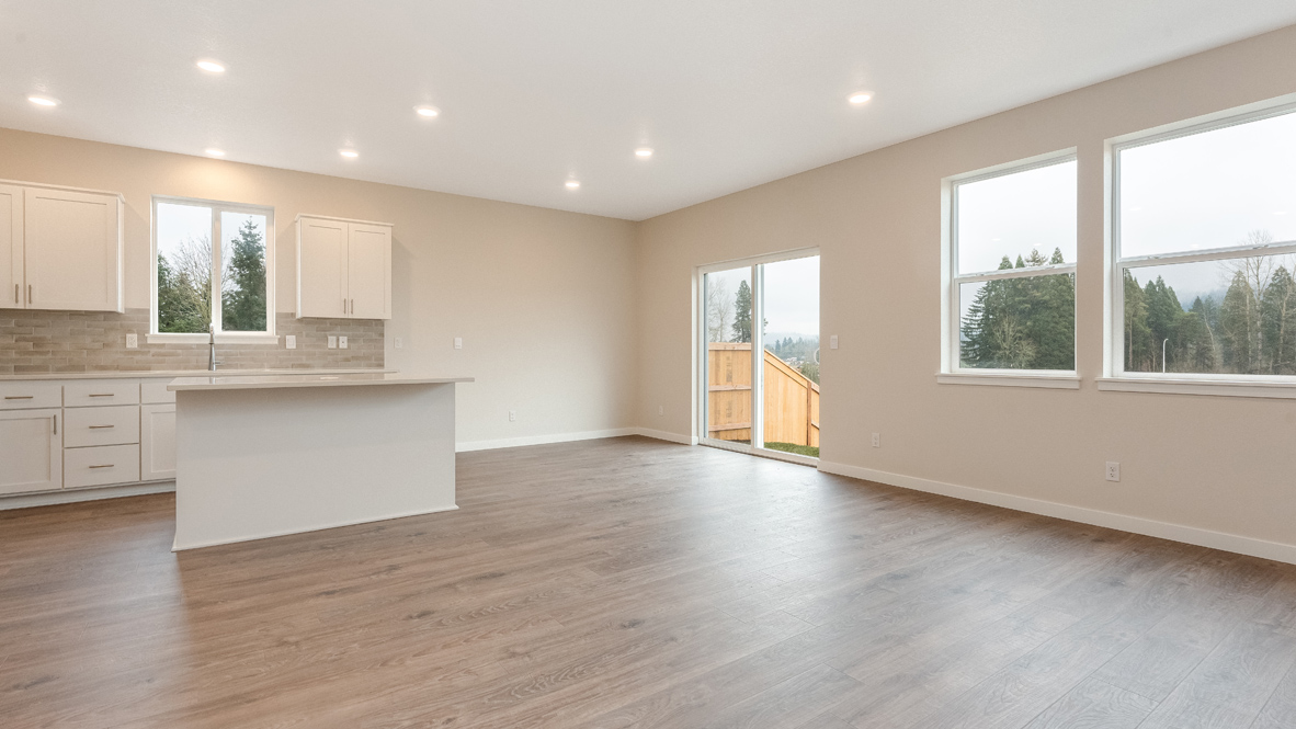 Avery Terrace dining and kitchen with laminate flooring, white walls, lights, an island, stainless steel appliances, and a window with a sliding glass door