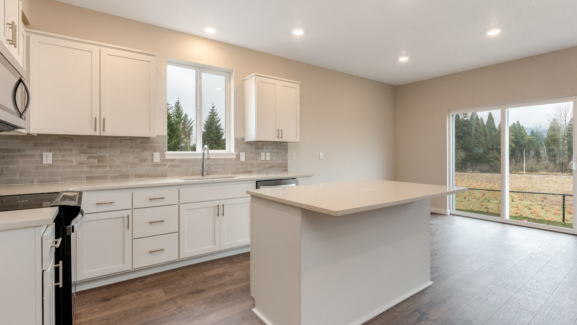 Avery Terrace kitchen with stainless appliances, quartz countertops, an island, a window, soft close cabinetry, laminate flooring, white walls, and sliding glass door