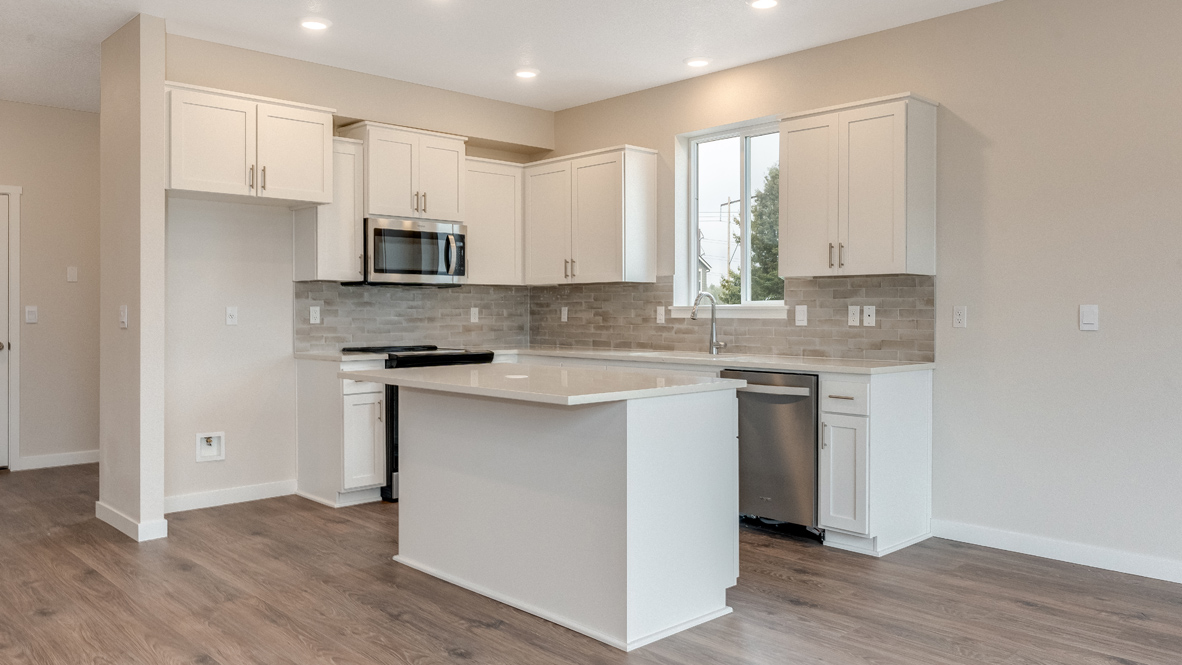 Avery Terrace kitchen with stainless appliances, quartz countertops, an island, a window, soft close cabinetry, laminate flooring, white walls