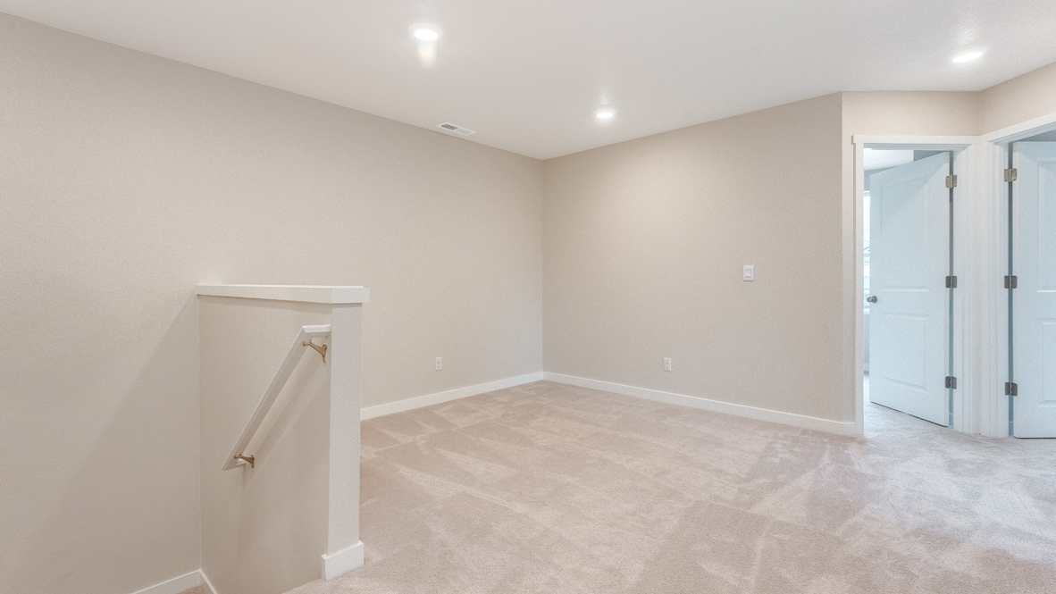 Avery Terrace loft with staircase, white carpet, white walls, lights, and view of bedrooms