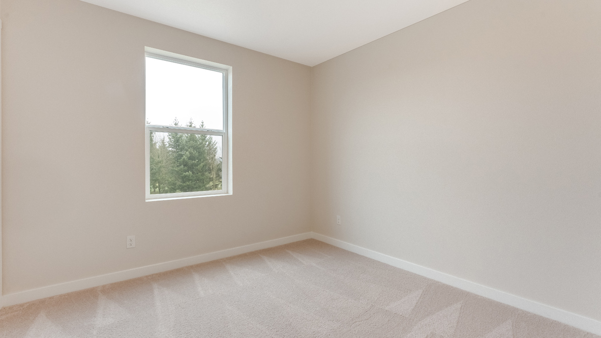 Avery Terrace bedroom with carpet, white walls, and a window