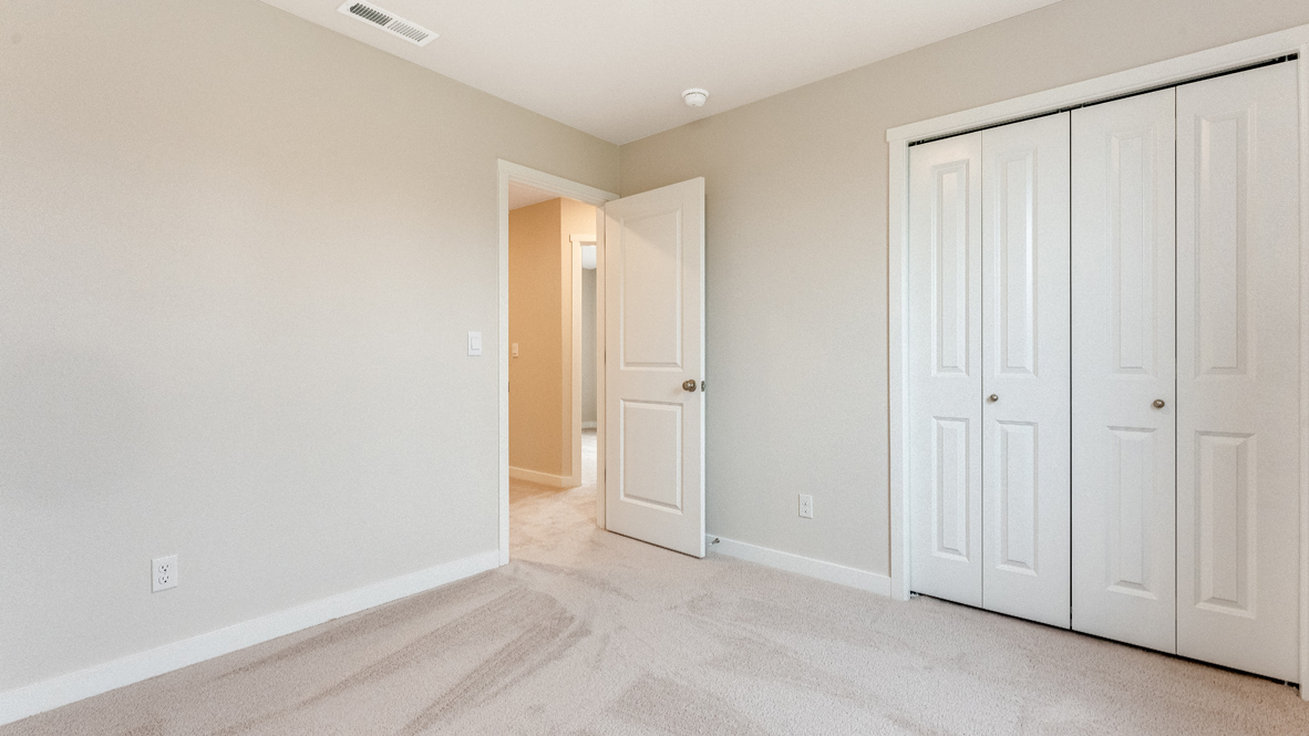 Avery Terrace bedroom with carpet, closet, walls, and door