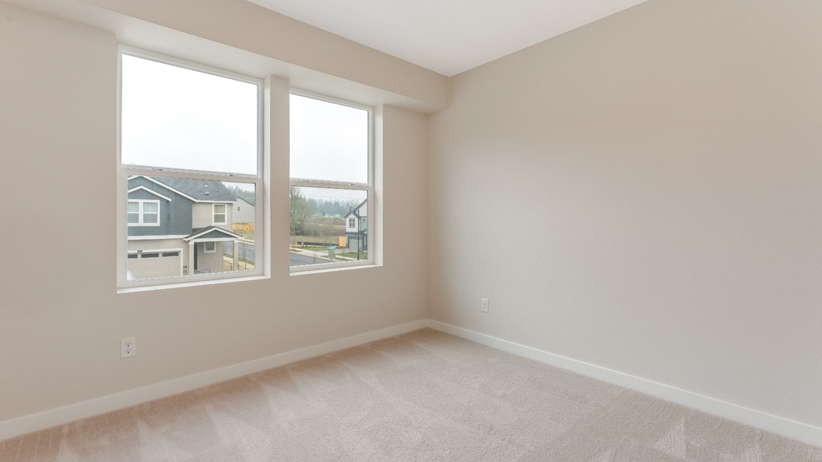 Avery Terrace bedroom with carpet, white walls, and a window