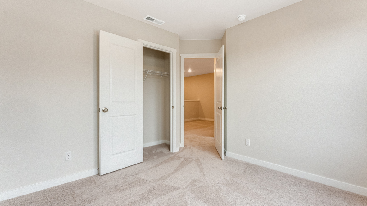 Avery Terrace bedroom with carpet, closet, walls, and door