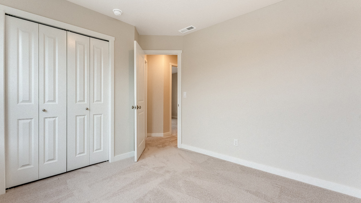 Avery Terrace bedroom with carpet, closet, walls, and door