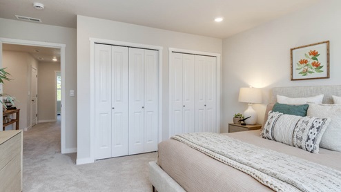 Gordon Creek Pointe Primary bedroom with carpet, bed with pillows and bedding, nightstand with lamp, closet
