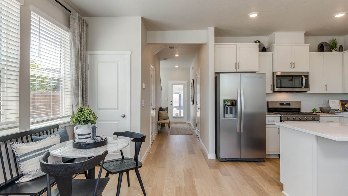 Gordon Creek Pointe Dining and kitchen with laminate flooring, small table with two chairs, windows, and the hallway in the background