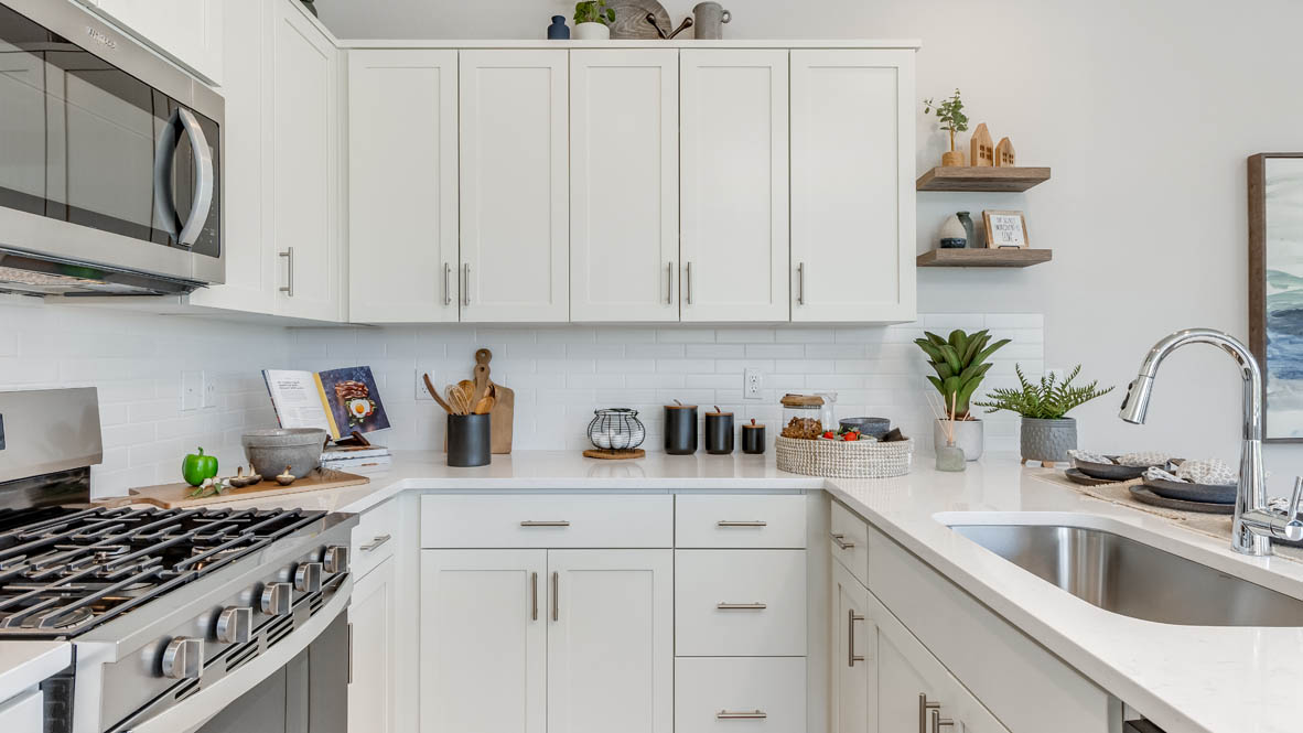 Gordon Creek Pointe Kitchen with a peninsula, barstool chairs, laminate flooring, quartz countertops, stainless steel appliances, drawers