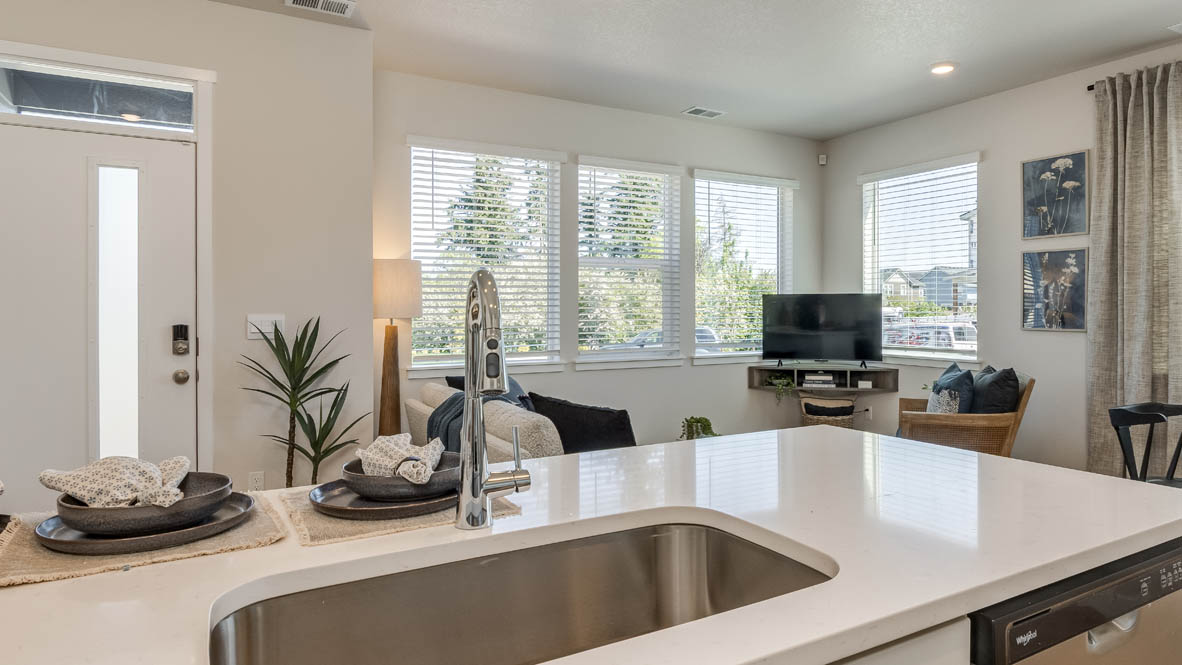 Gordon Creek Pointe Kitchen with a peninsula, barstool chairs, laminate flooring, quartz countertops, stainless steel appliances, drawers