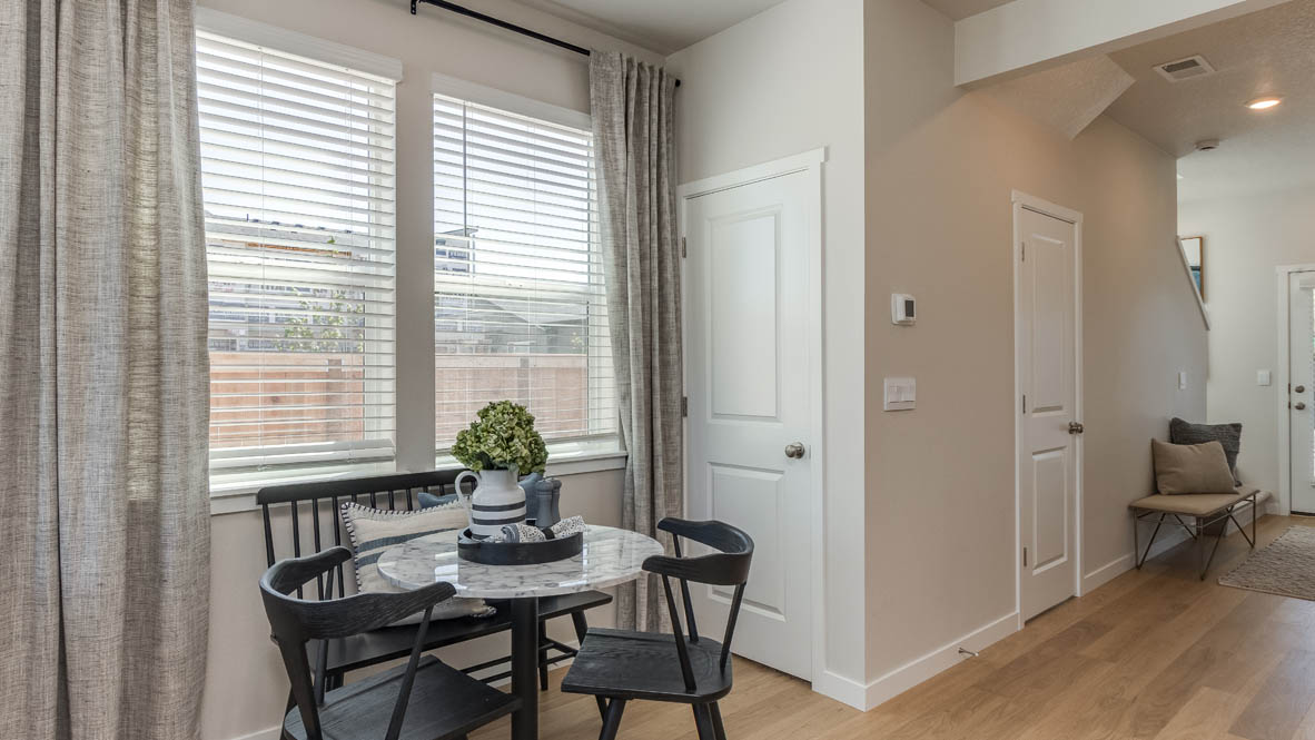 Gordon Creek Pointe dining room with windows, blinds, curtains, table with chairs, and the hallway in the background