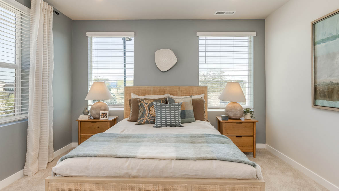 Gordon Creek Pointe Primary bedroom with carpet, windows, nightstand with lamp, bedding, two decorative paintings