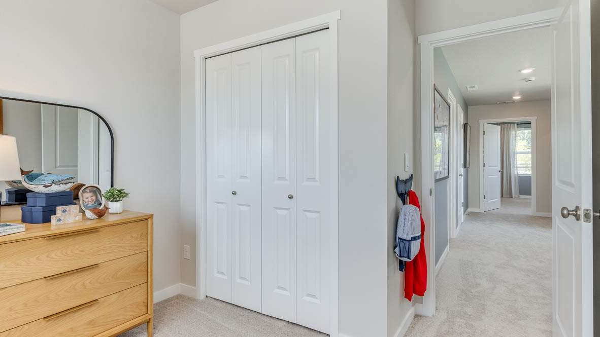 Gordon Creek Pointe bedroom with bedding, carpet, nightstand with lamp, and closet