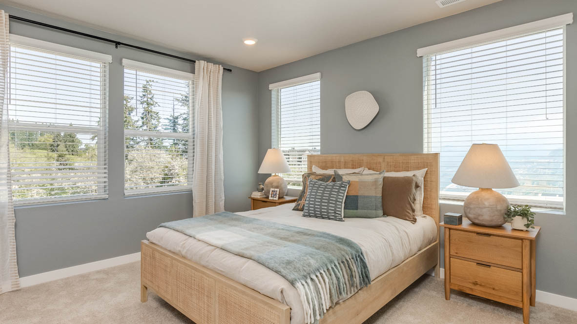 Gordon Creek Pointe Primary bedroom with carpet, windows, nightstand with lamp, bedding, two decorative paintings