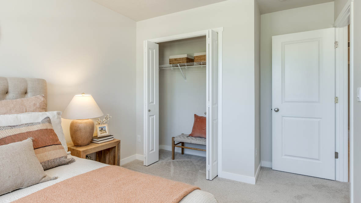 Gordon Creek Pointe bedroom with bedding, carpet, nightstand with lamp, and closet