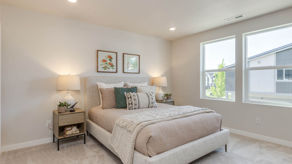 Gordon Creek Pointe Primary bedroom with carpet, windows, nightstand with lamp, bedding, two decorative paintings