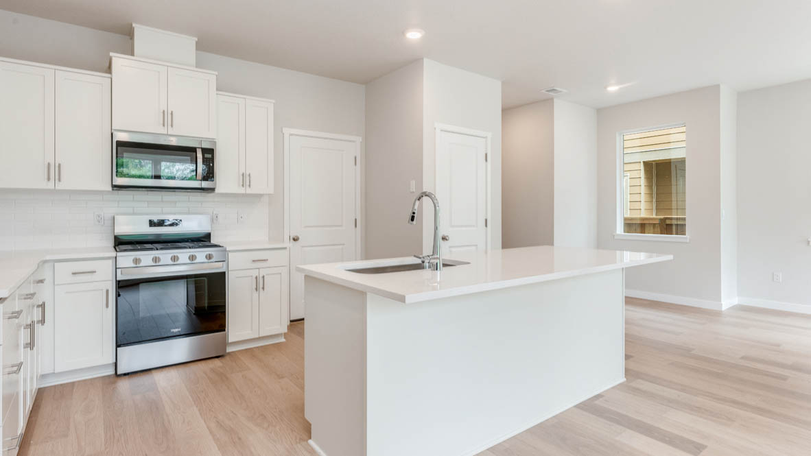 Gordon Creek Pointe Kitchen with island, quartz countertops, white shaker cabinets, and stainless steel appliances
