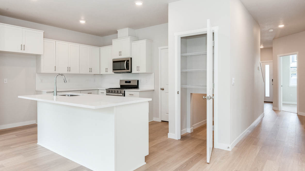 Gordon Creek Pointe Kitchen with island, quartz countertops, white shaker cabinets, and stainless steel appliances