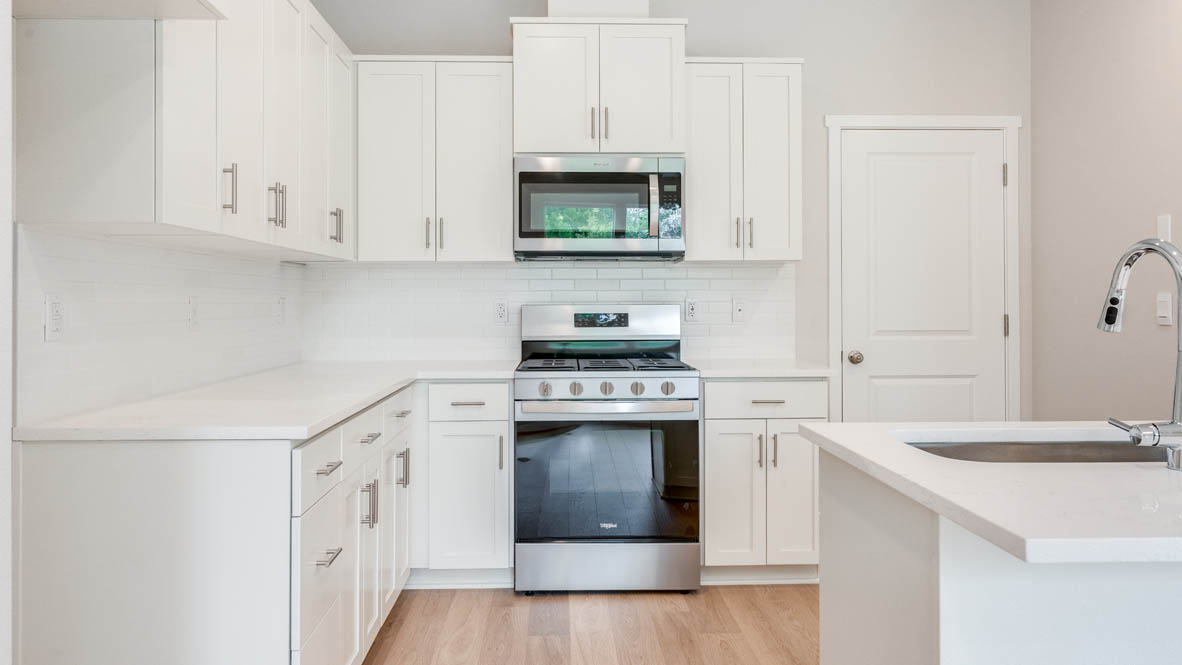 Gordon Creek Pointe Kitchen with island, quartz countertops, white shaker cabinets, and stainless steel appliances